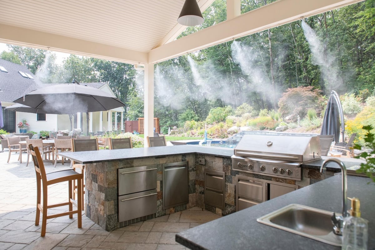 Black and white modern farmhouse renovation in acton, massachusetts with outdoor kitchen entertainment area