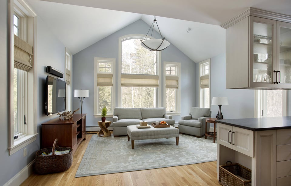 Bright and airy living room in a Boston home addition by Thomas Buckborough, featuring vaulted ceilings and large windows