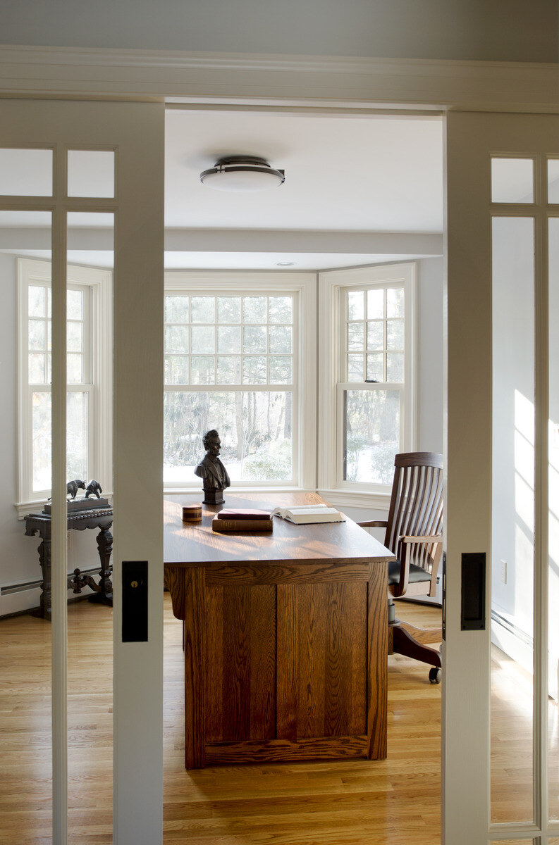 Traditional home office featuring a handcrafted wooden desk and elegant French doors, part of a renovation in Boston, MA Traditional home office featuring a handcrafted wooden desk and elegant French doors, part of a renovation in Boston, MA