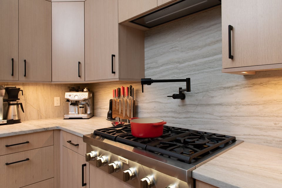 Modern kitchen remodel with a blue and white color scheme and a custom wood breakfast nook in Boston