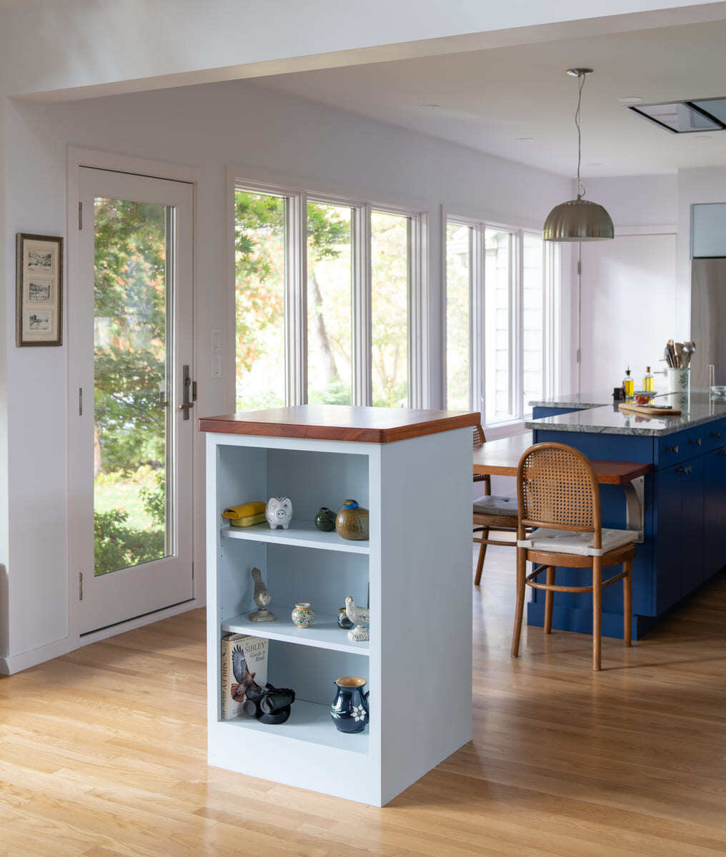 A thoughtfully designed storage nook featuring ceramic vases and books, enhancing the kitchen’s functionality