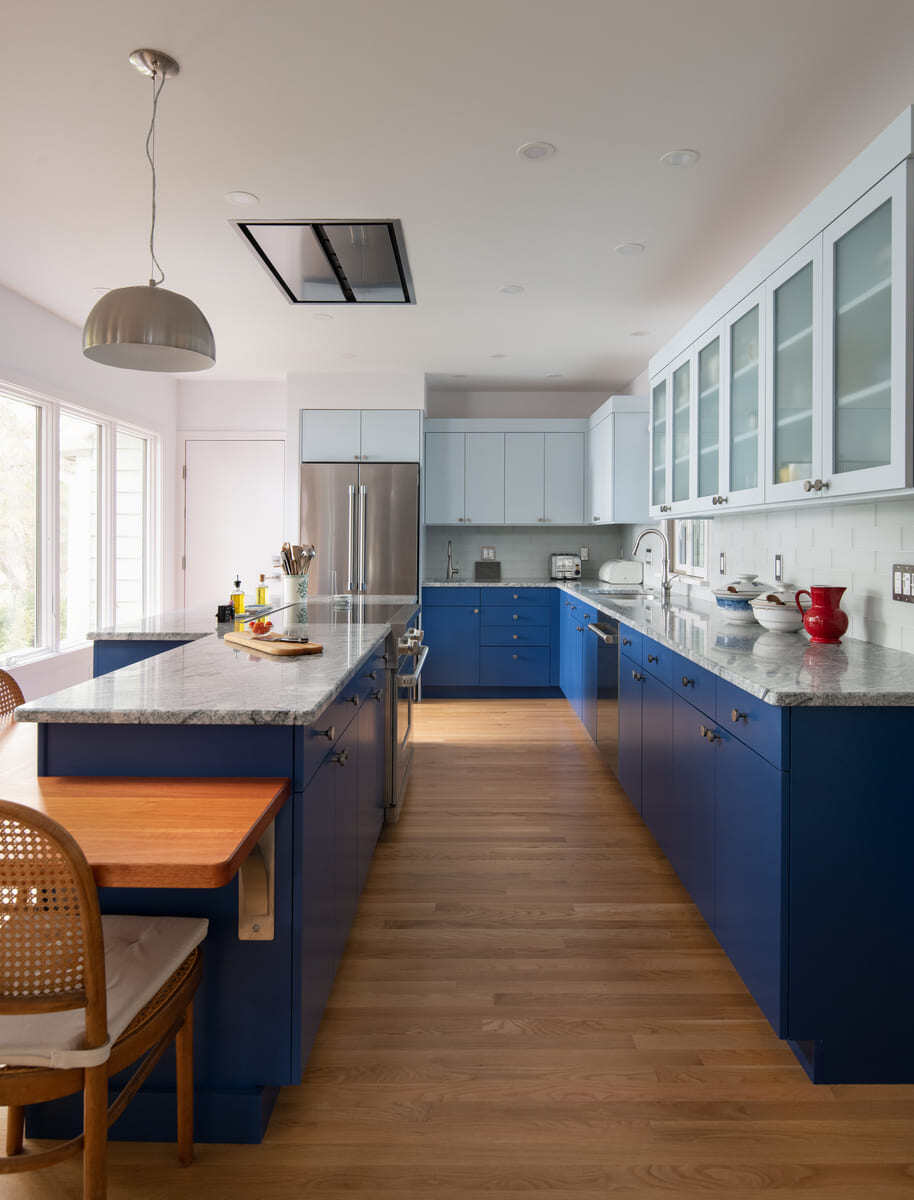 Elegant kitchen renovation in Acton, MA, with blue cabinetry, marble countertops, and modern lighting by Thomas Buckborough & Associates