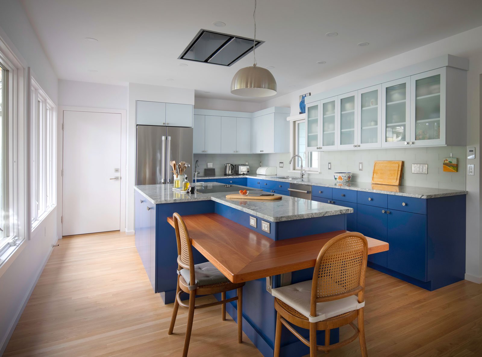 Modern kitchen remodel in Acton, MA, featuring blue lower cabinets and light upper cabinets by Thomas Buckborough & Associates