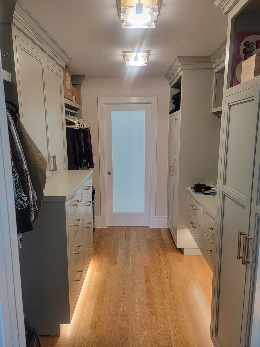 A beautifully designed walk-in closet with custom cabinetry, soft lighting, and ample storage space in a remodeled home in Acton, MA