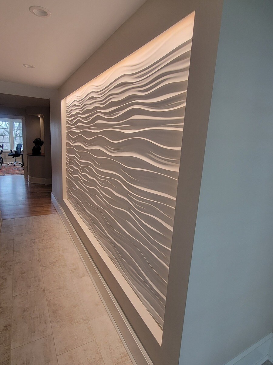 A stylish hallway with a sculptural wave panel, designed to add visual interest to a luxury remodel by Thomas Buckborough & Associates