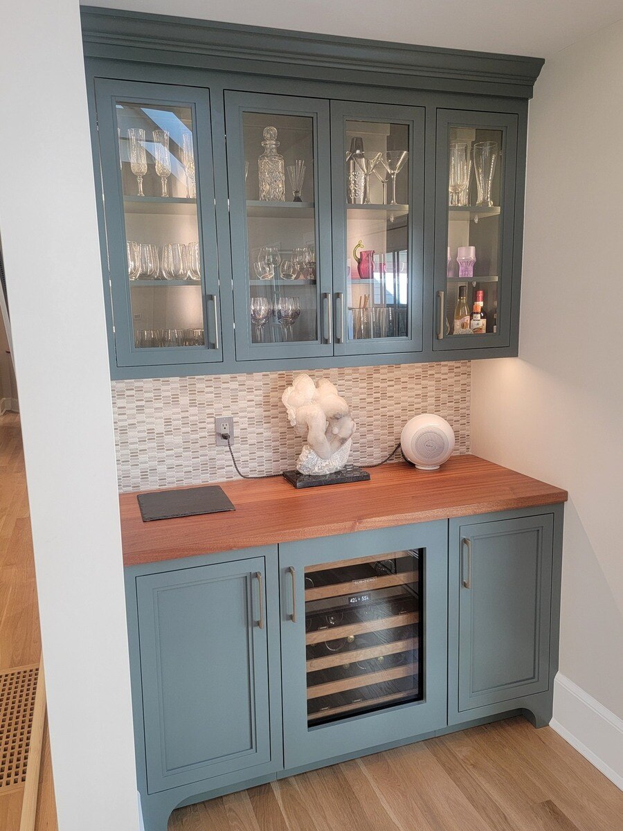 Built-in home bar with glass-front cabinets and a wine fridge, designed for a home renovation in Acton, MA, by Thomas Buckborough & Associates