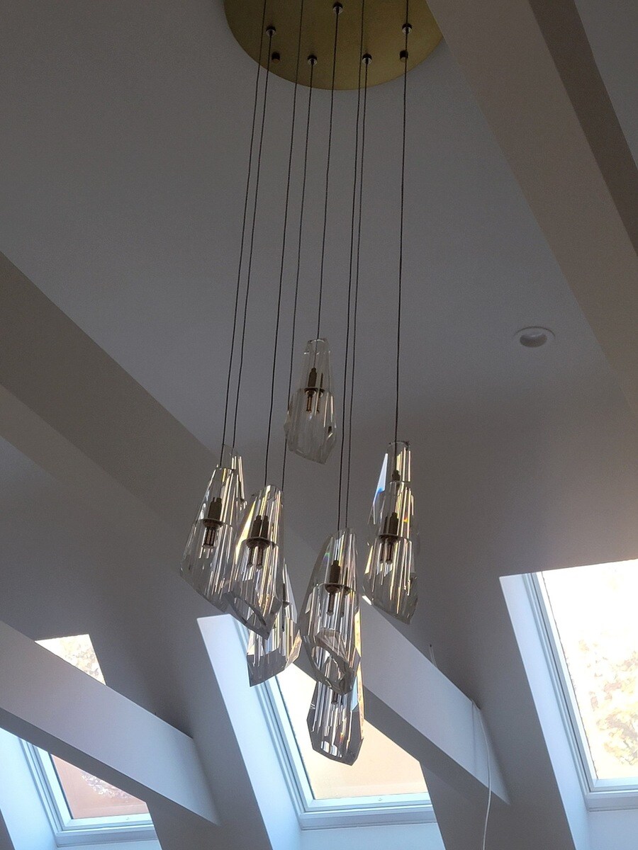 Elegant cascading glass light fixture complementing a modern home renovation by Thomas Buckborough & Associates in Acton, MA