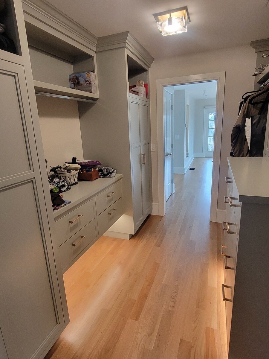 Elegant storage space featuring built-in shelves, drawers, and a modern light fixture in a high-end home renovation