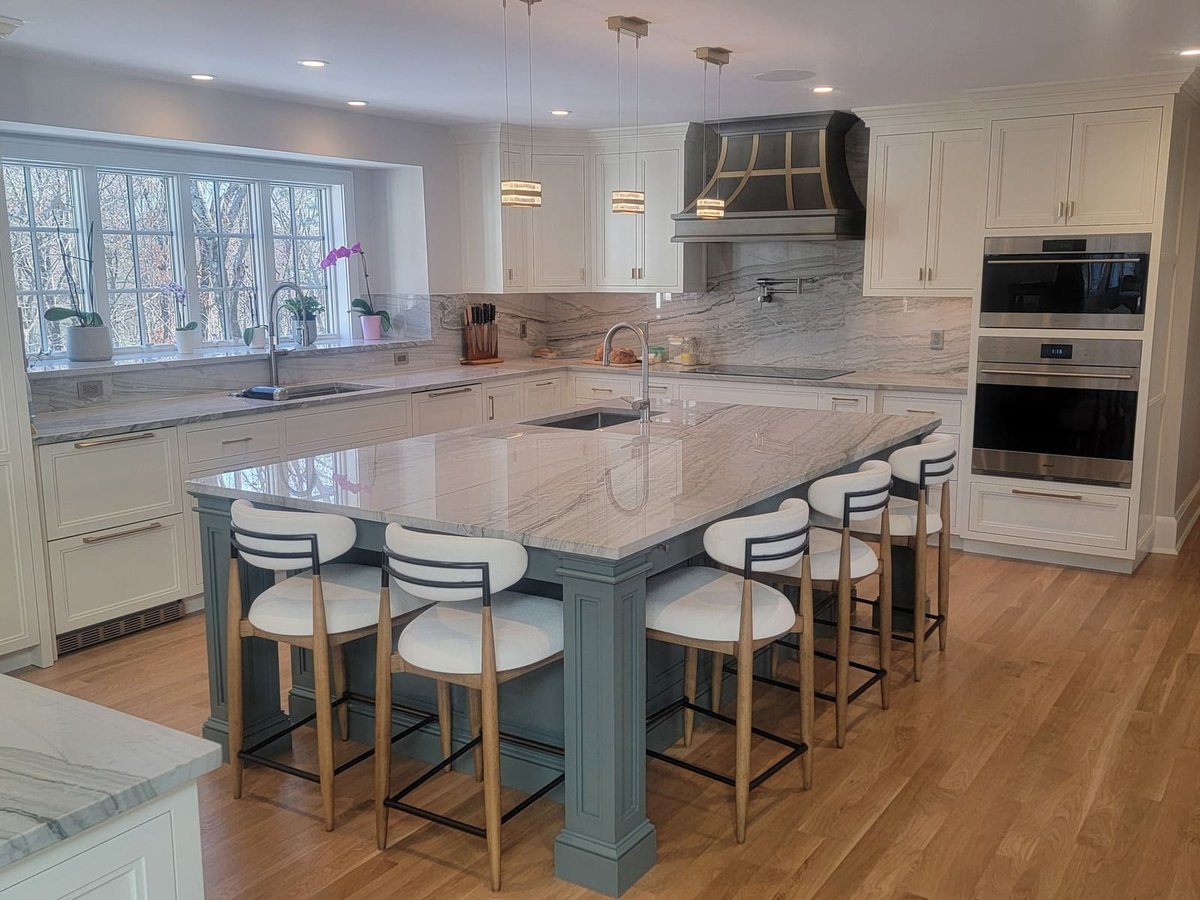 Luxury kitchen upgrade with a waterfall marble island and top-of-the-line appliances, crafted by Thomas Buckborough & Associates in Acton, MA