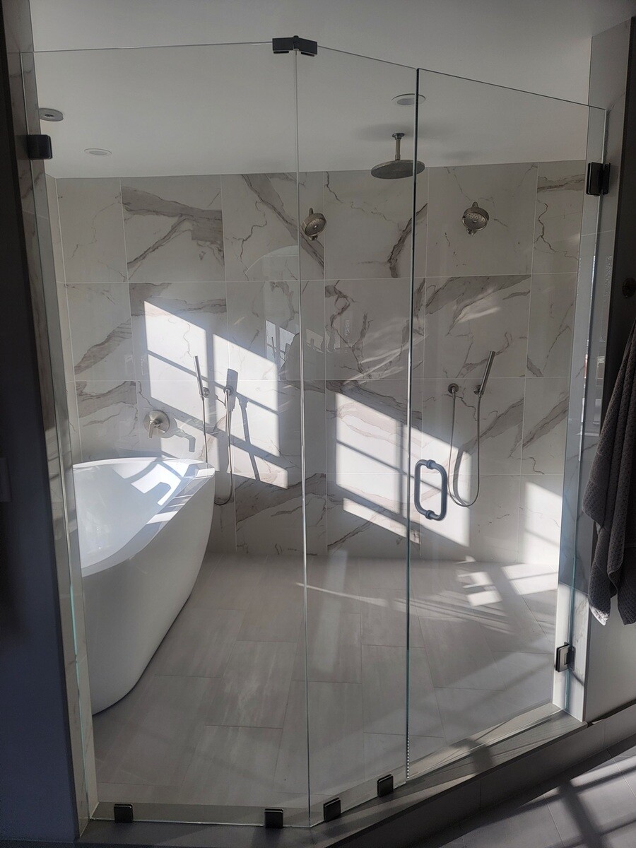 Luxury shower design with a glass partition, custom fixtures, and a sleek modern aesthetic in the Frankel remodel by Thomas Buckborough & Associates