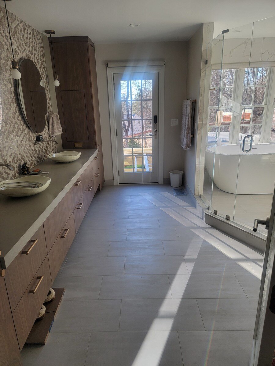 Modern bathroom with a sleek vanity, large mirrors, and a glass-enclosed shower in a Frankel remodel in Acton, MA