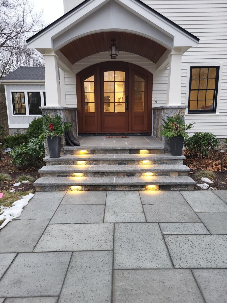 Stunning front entryway transformation with an arched portico, stone steps, and warm accent lighting in Acton, MA