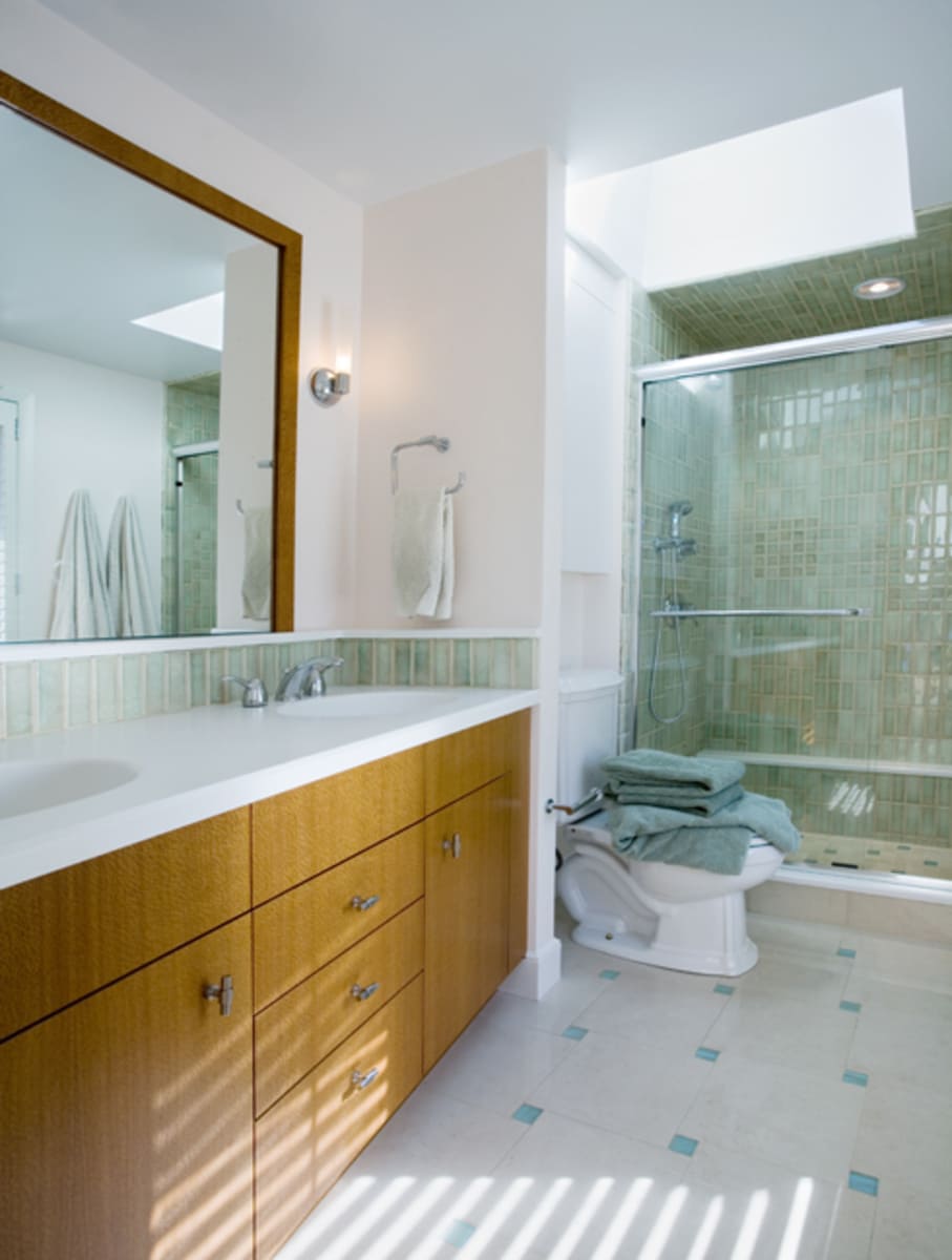 Custom bathroom with a sleek double vanity and glass-enclosed shower, part of a home remodel by Thomas Buckborough & Associates