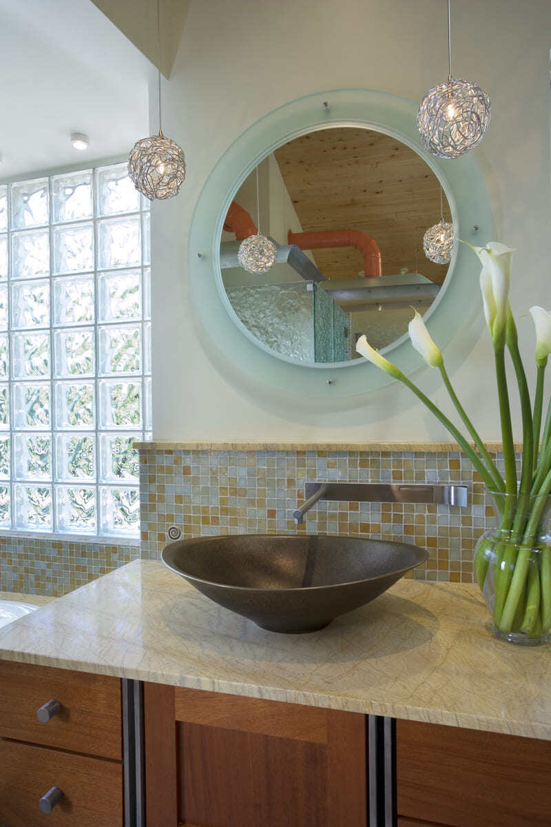 Elegant bathroom sink area featuring a dark stone basin and custom tile backsplash in an Acton, MA home remodel