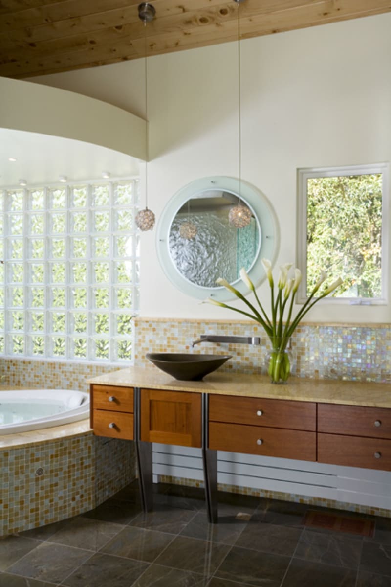 Modern bathroom sink design featuring a stone vessel basin and wall-mounted faucet in a luxury home remodel