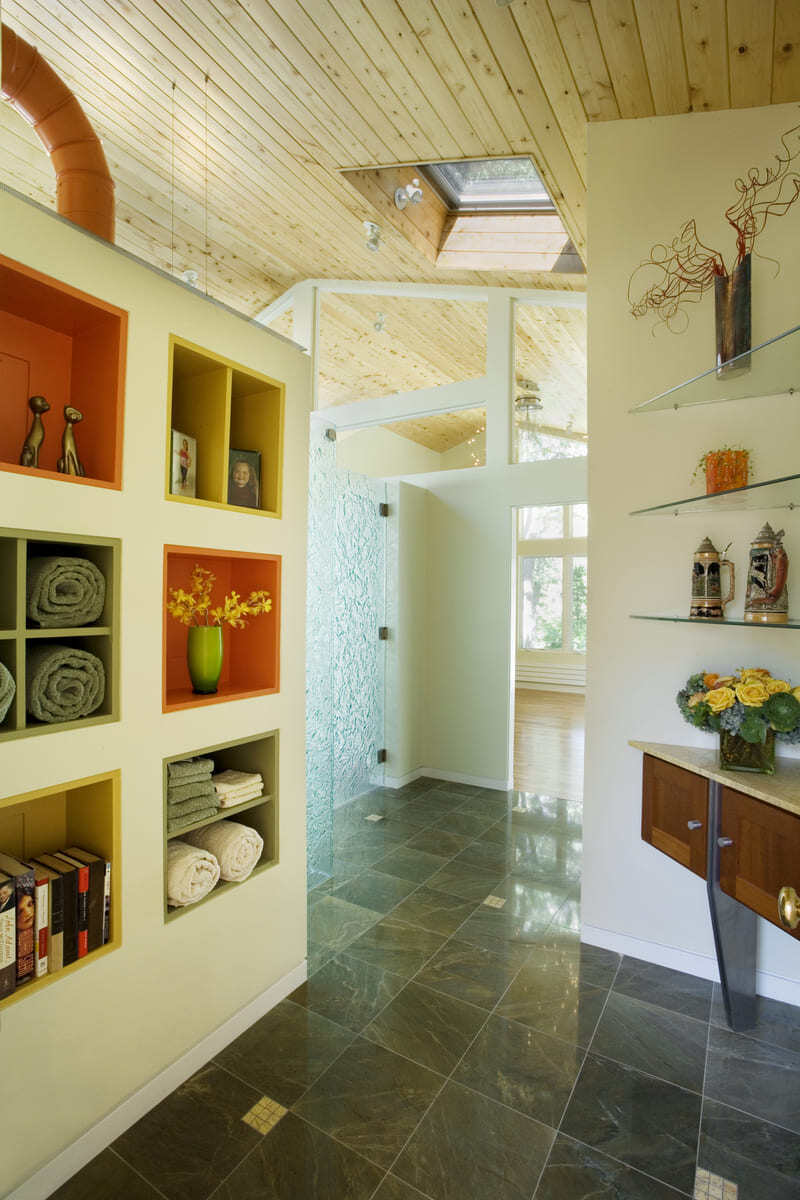 Open-concept bathroom with custom built-in shelving, glass partitions, and wood ceiling by Thomas Buckborough & Associates in Acton, MA