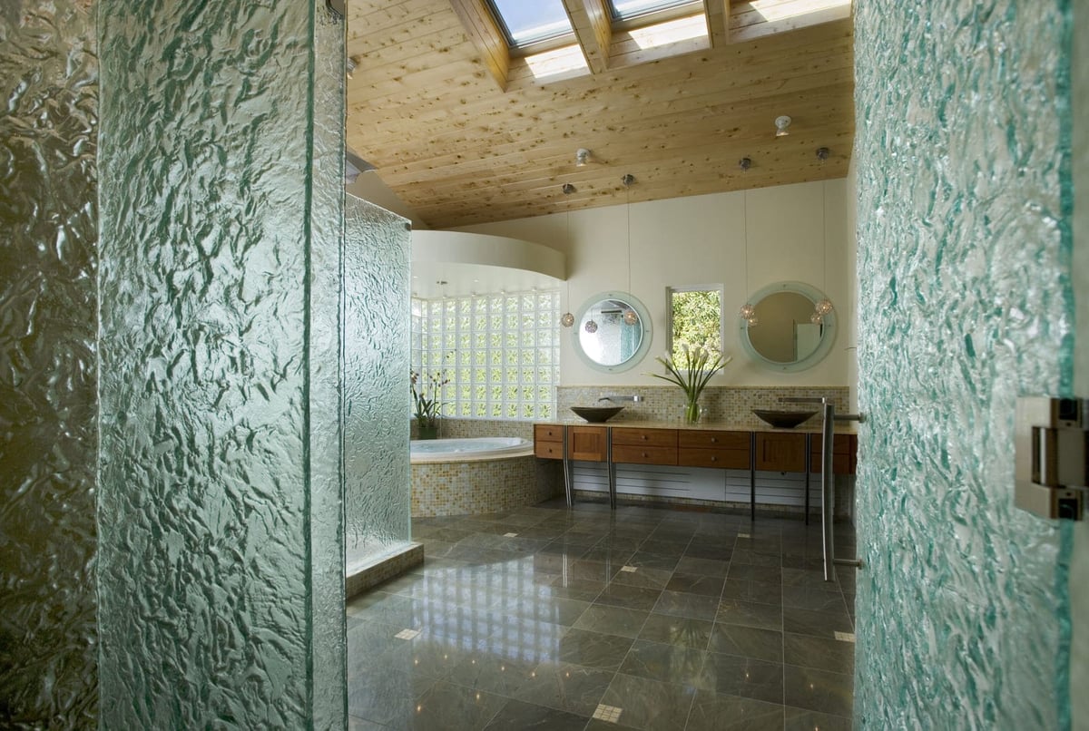 Stunning bathroom with textured glass doors, natural wood ceiling, and luxurious soaking tub, designed by Thomas Buckborough & Associates in Acton, MA