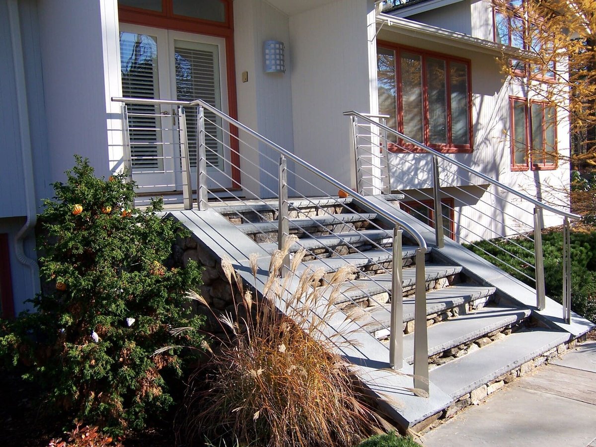 Stylish metal and cable stair railing leading to the front entrance of a modern home in Acton, MA