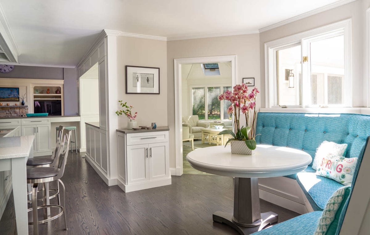 Bright and airy breakfast nook with a contemporary white table and plush seating in a kitchen renovation by Thomas Buckborough & Associates in Acton, MA