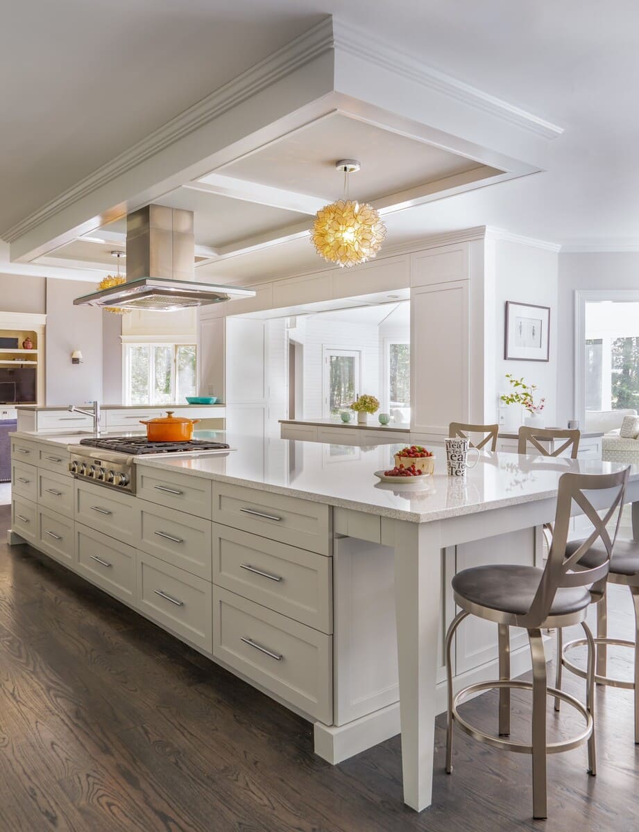 Open-concept kitchen featuring a large quartz island and elegant pendant lighting, designed by Thomas Buckborough & Associates in Acton, MA