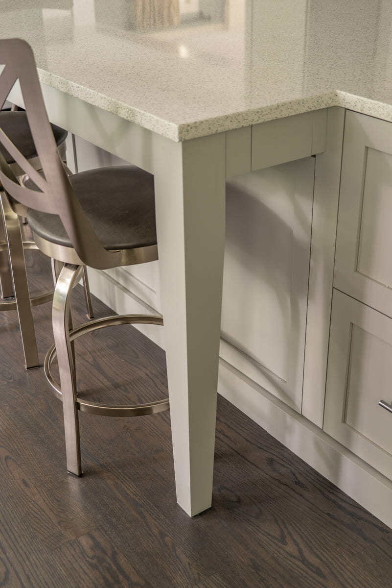 Retractable power outlet tucked under a kitchen island countertop in an Acton, MA, remodel by Thomas Buckborough & Associates