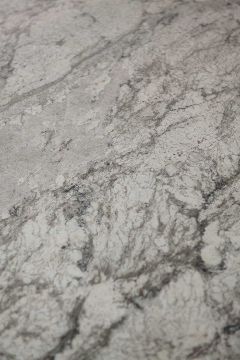 A detailed view of a marble kitchen countertop with intricate gray veining in a home renovation by Thomas Buckborough & Associates