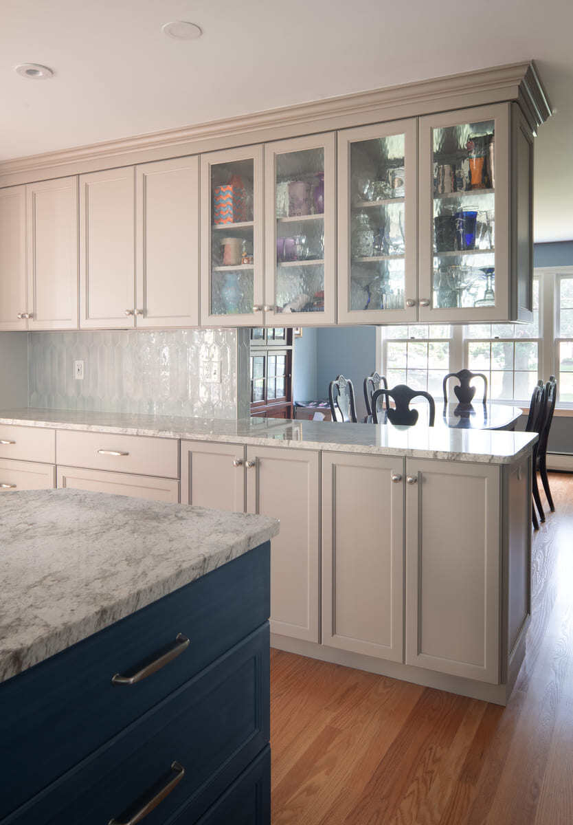 A kitchen remodel in Acton, MA, with a high-end range, marble backsplash, and custom cabinetry by Thomas Buckborough & Associates