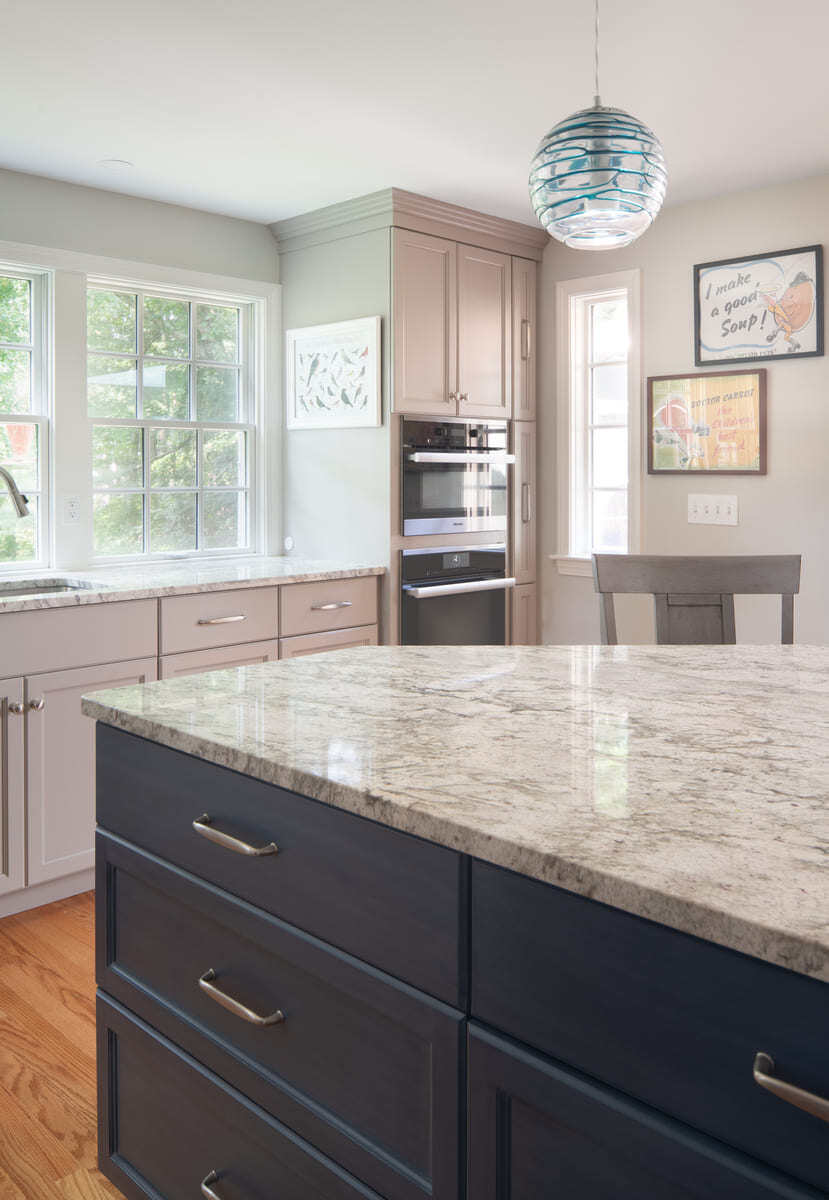 A modern kitchen renovation in Acton, MA, with quartz countertops, white cabinetry, and a stylish backsplash by Thomas Buckborough & Associates