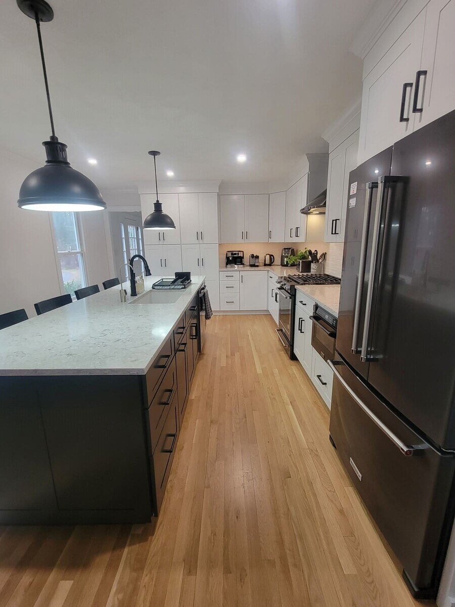 Open kitchen design with functional storage, contemporary lighting, and high-end finishes by Thomas Buckborough & Associates
