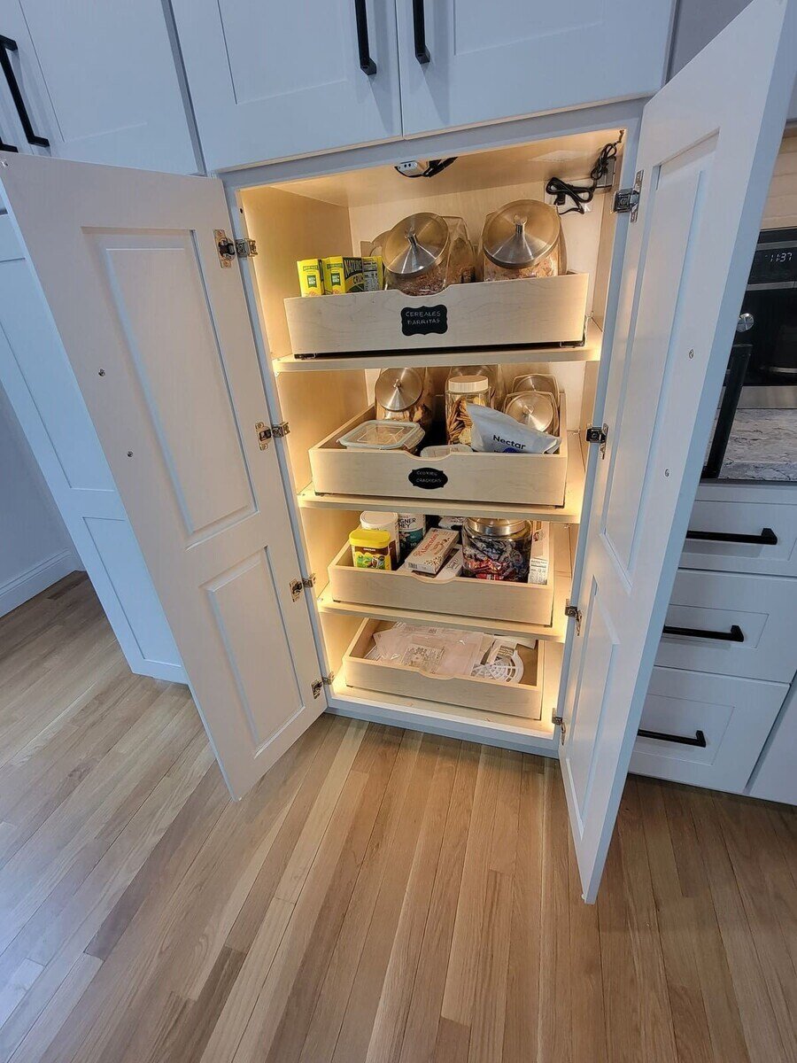 Organized pantry cabinet with pull-out shelves and labeled storage in a custom kitchen remodel in Acton, MA