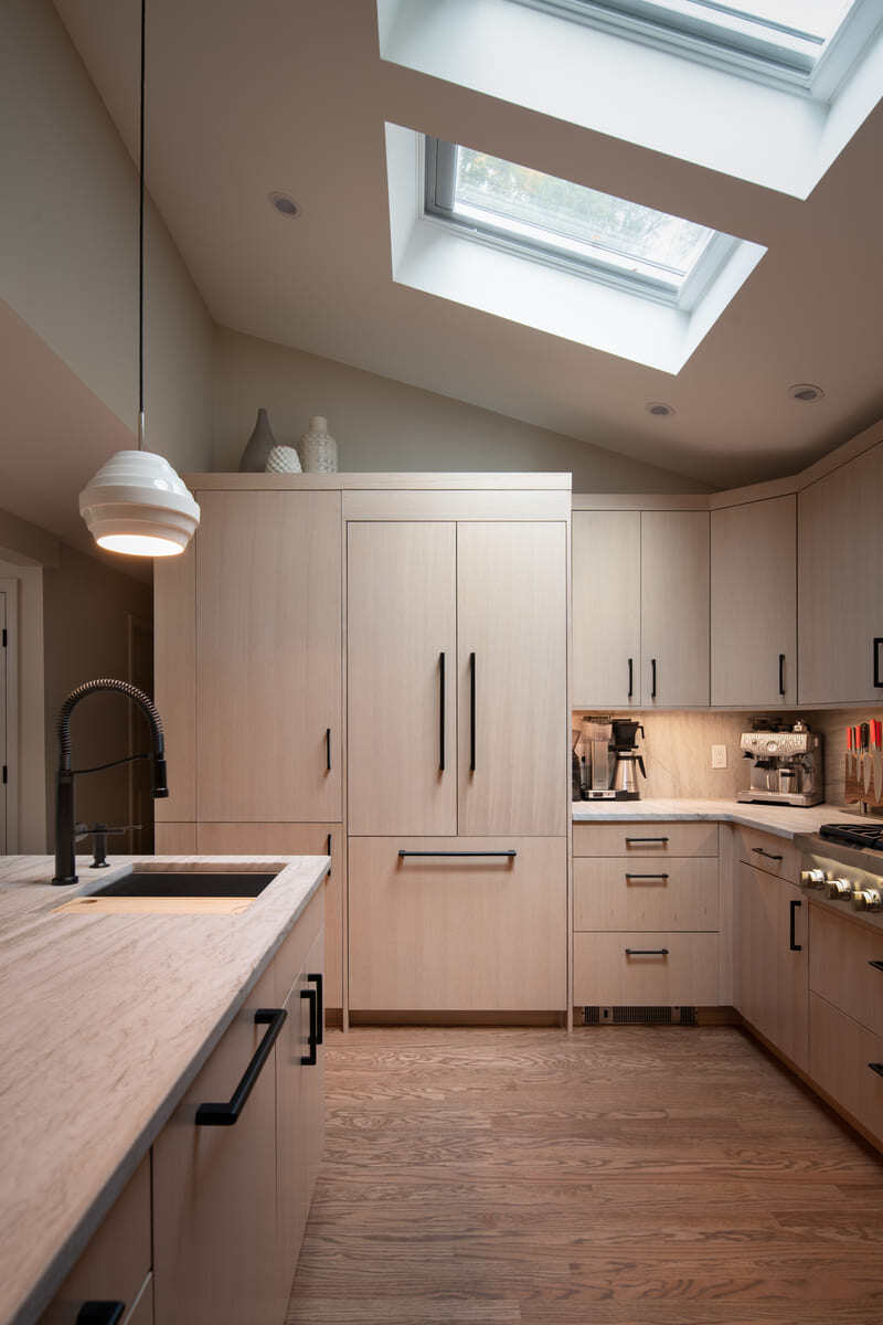 Close-up of a custom kitchen remodel with light wood cabinetry, skylights, and black hardware in a Shea home in Acton, MA