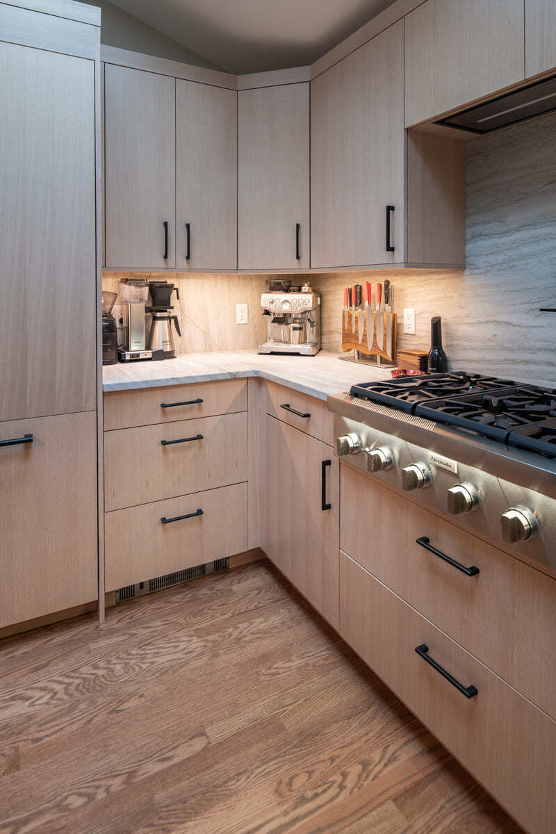 Elegant kitchen renovation with a fully stocked custom pantry and built-in shelving in a Shea home by Thomas Buckborough & Associates in Acton, MA