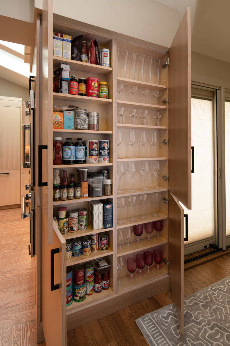 Modern kitchen with a built-in fridge and overhead skylights in a Shea home remodel by Thomas Buckborough & Associates in Acton, MA