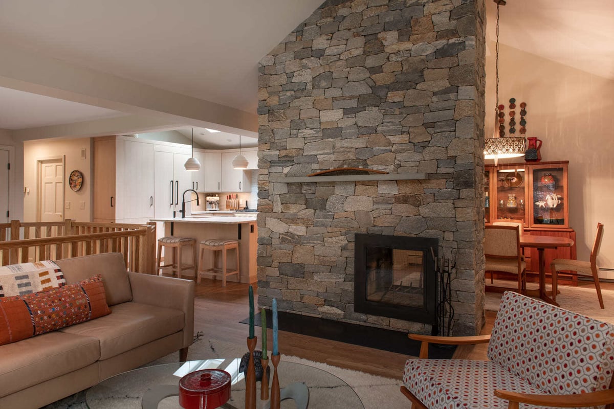 Rustic-modern interior with a floor-to-ceiling stone fireplace and custom kitchen remodel in a Shea home