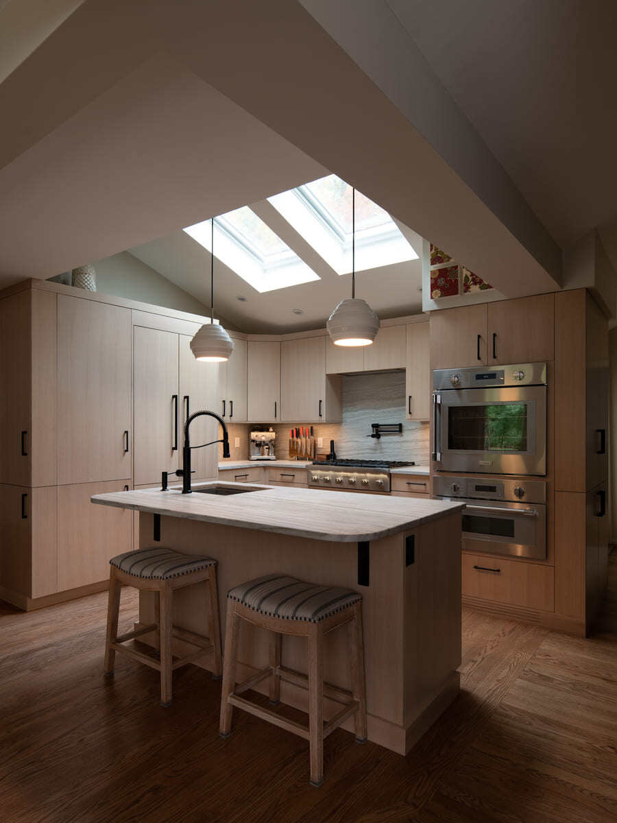 Shea home kitchen remodel with a marble countertop island and pendant lighting by Thomas Buckborough & Associates in Acton, MA