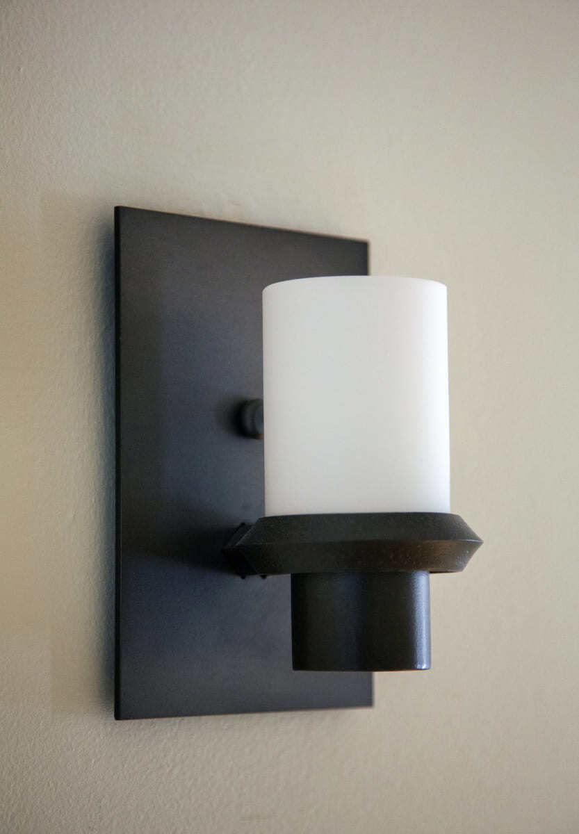 Contemporary black and white wall-mounted lighting fixture featured in home renovation by Thomas Buckborough & Associates, Acton, MA