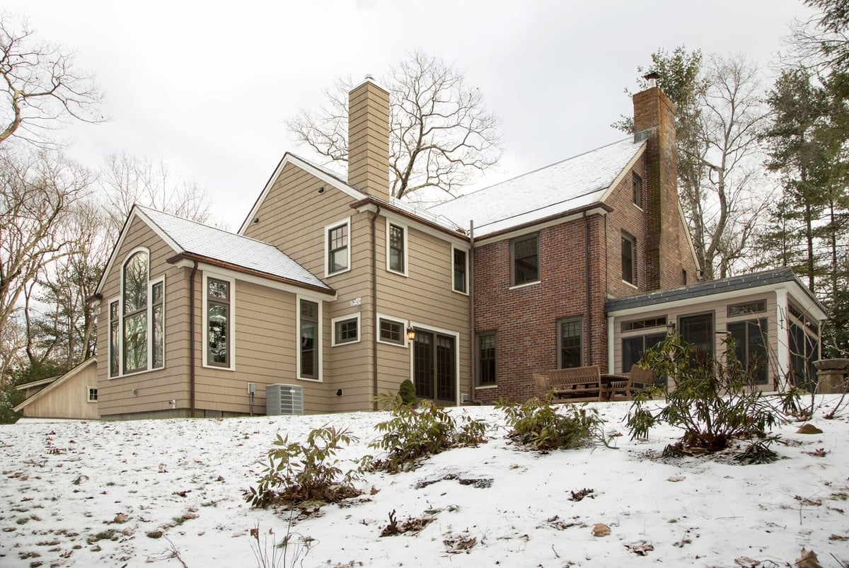 Expansive home renovation with a thoughtfully designed addition, featuring large arched windows and updated siding by Thomas Buckborough & Associates, Acton, MA