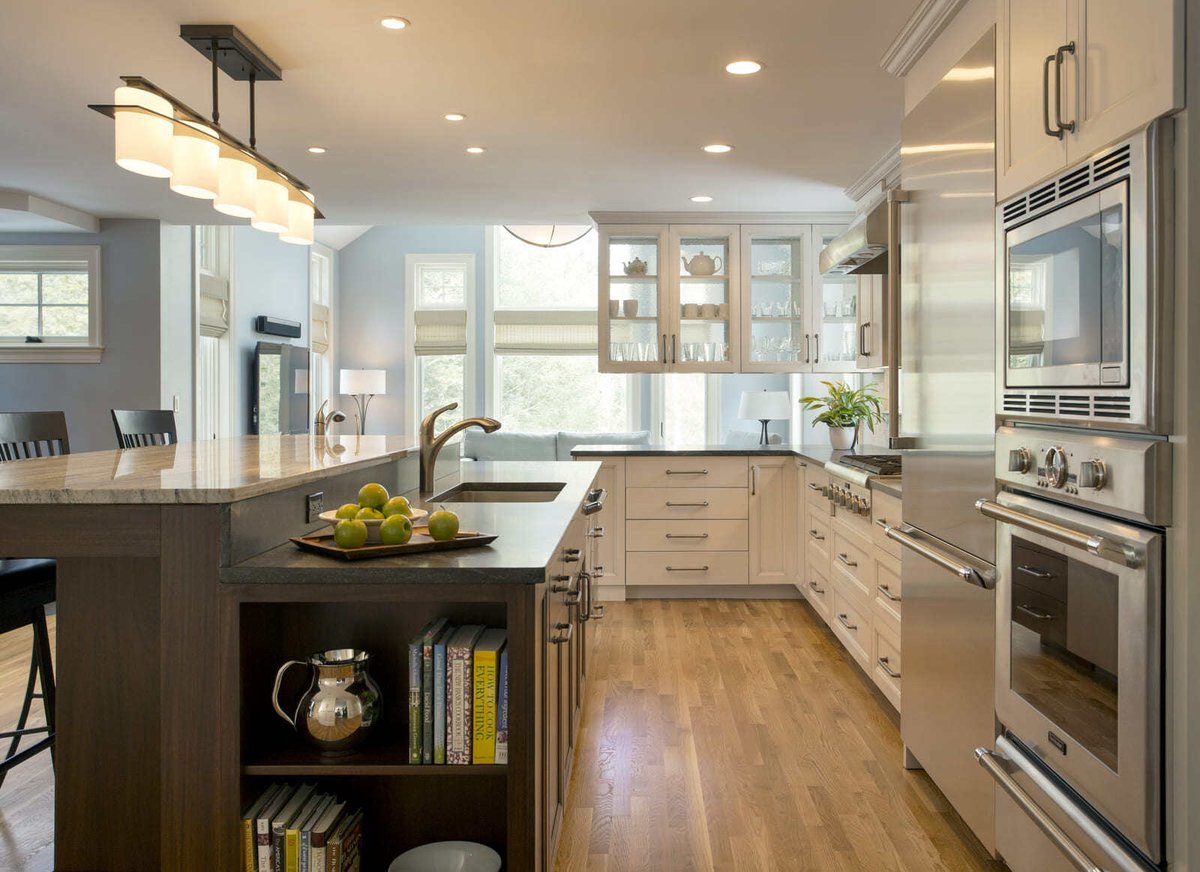 High-end kitchen design with glass-front cabinets, stainless steel appliances, and a sleek modern island by Thomas Buckborough & Associates, Acton, MA