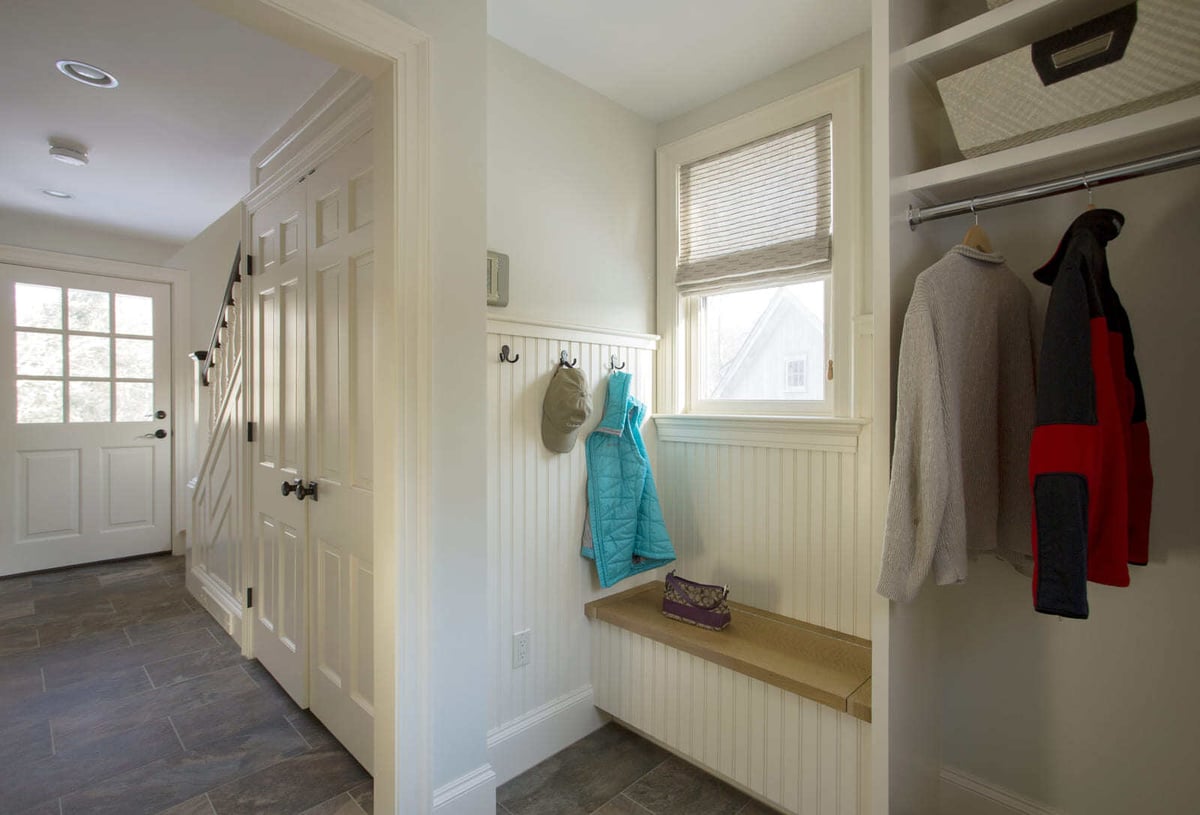 Home entryway renovation featuring beadboard paneling, a cozy bench seat, and built-in coat storage by Thomas Buckborough & Associates, Acton, MA