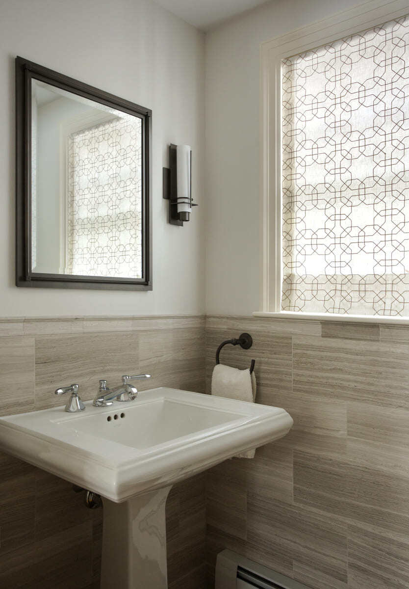 Minimalist bathroom with a pedestal sink and geometric window shades in a remodeling project by Thomas Buckborough & Associates, Acton, MA