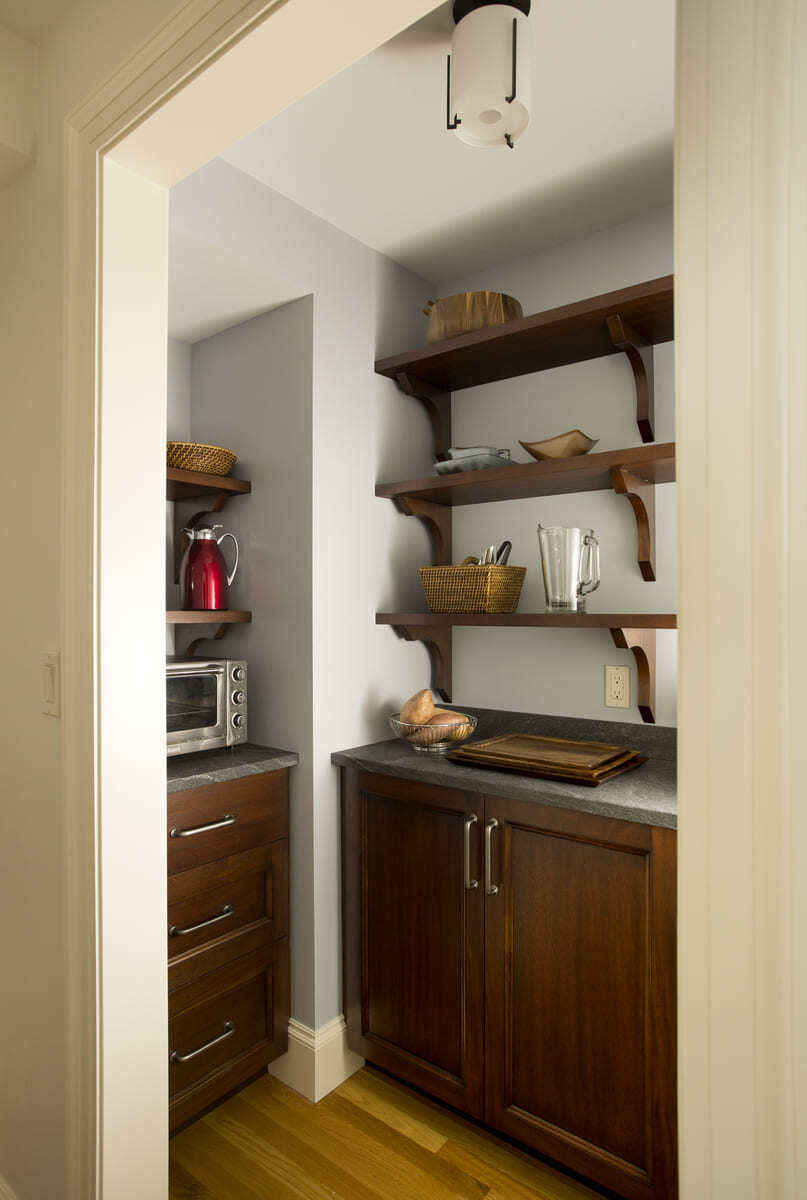 Modern pantry design with dark wood cabinets and open shelving by Thomas Buckborough & Associates in Acton, MA
