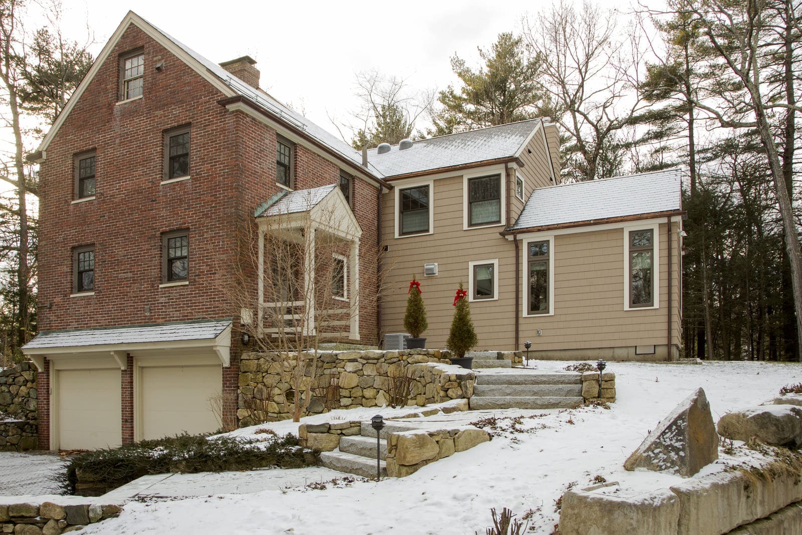 Snow-covered exterior of a classic brick home with a modernized rear addition by Thomas Buckborough & Associates, Acton, MA