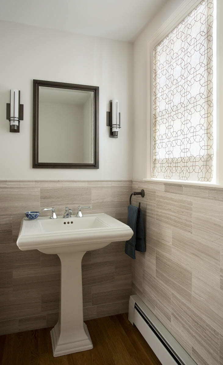 Sophisticated powder room with sleek lighting and a classic pedestal sink in a remodel by Thomas Buckborough & Associates, Acton, MA