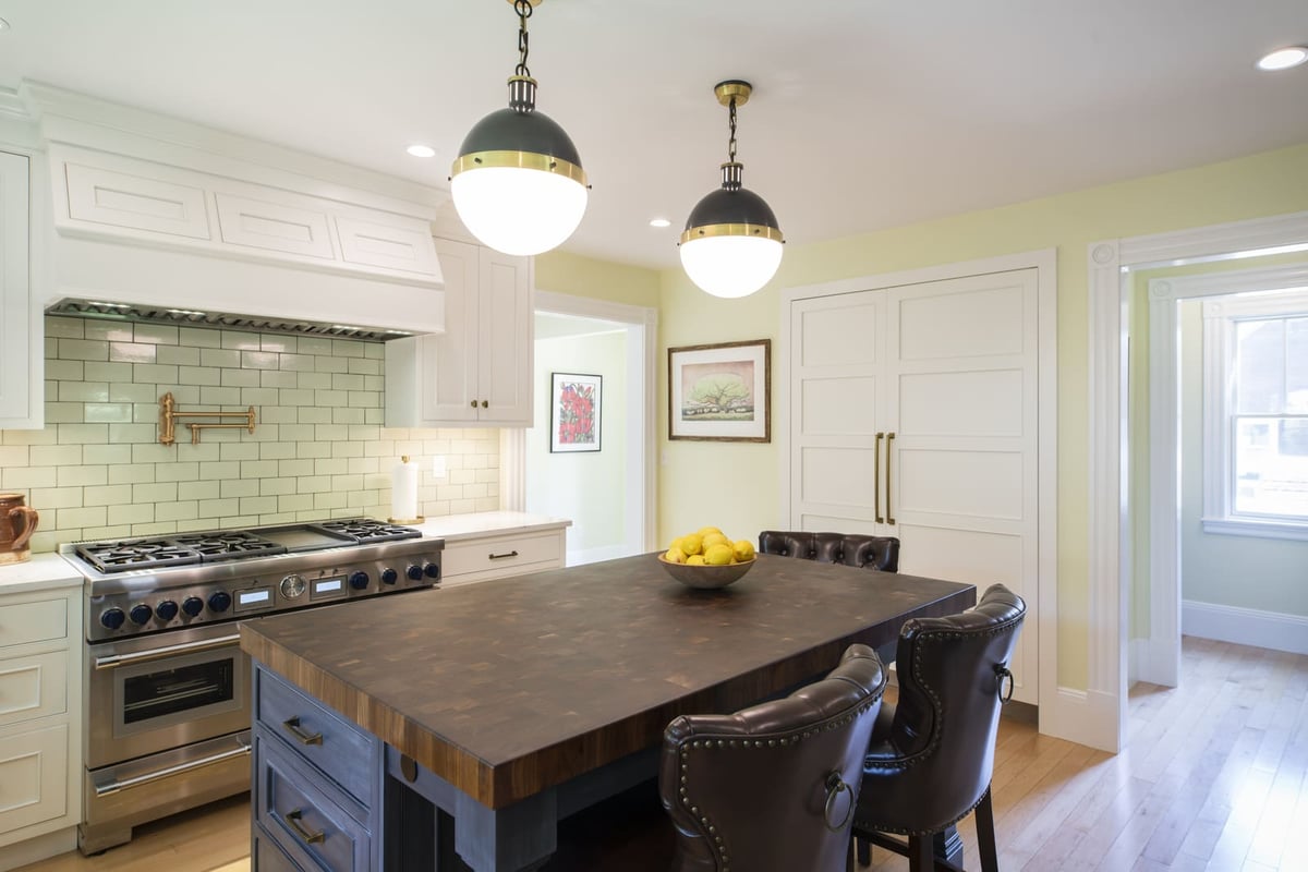 A beautifully remodeled kitchen featuring shaker cabinets, a double oven, and a farmhouse-inspired aesthetic by Thomas Buckborough & Associates