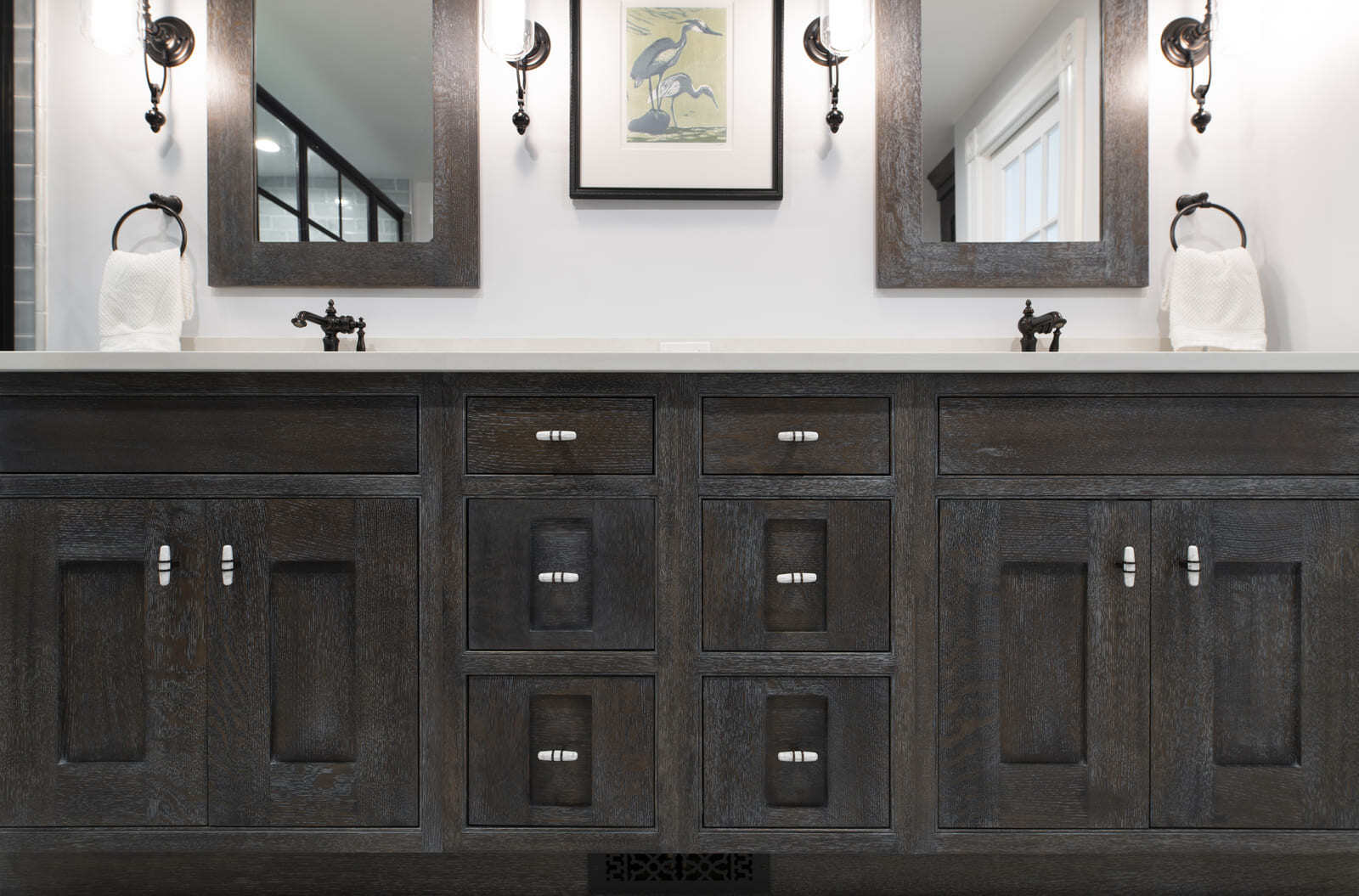 A sophisticated master bathroom vanity with custom wood cabinetry, stylish hardware, and soft ambient lighting in an Acton, MA remodel