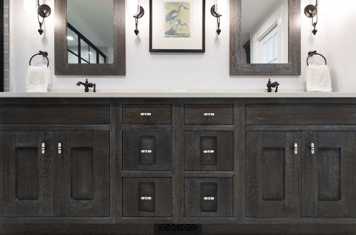 A sophisticated master bathroom vanity with custom wood cabinetry, stylish hardware, and soft ambient lighting in an Acton, MA remodel