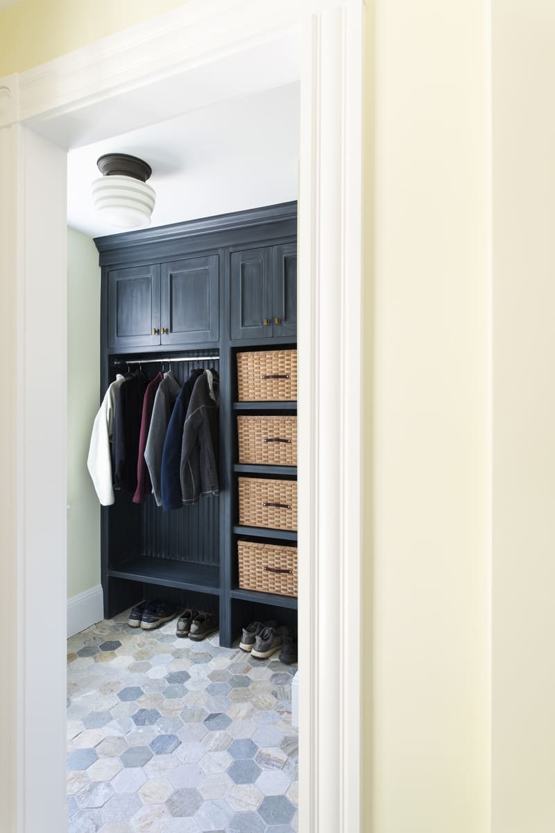 Entryway storage solution with a built-in closet system and stylish organization in a Thomas Buckborough & Associates home renovation