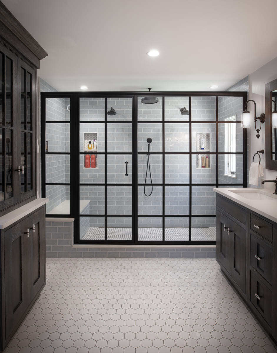 Modern and elegant master bathroom featuring a luxurious walk-in shower with black-framed glass doors and rain showerheads by Thomas Buckborough & Associates