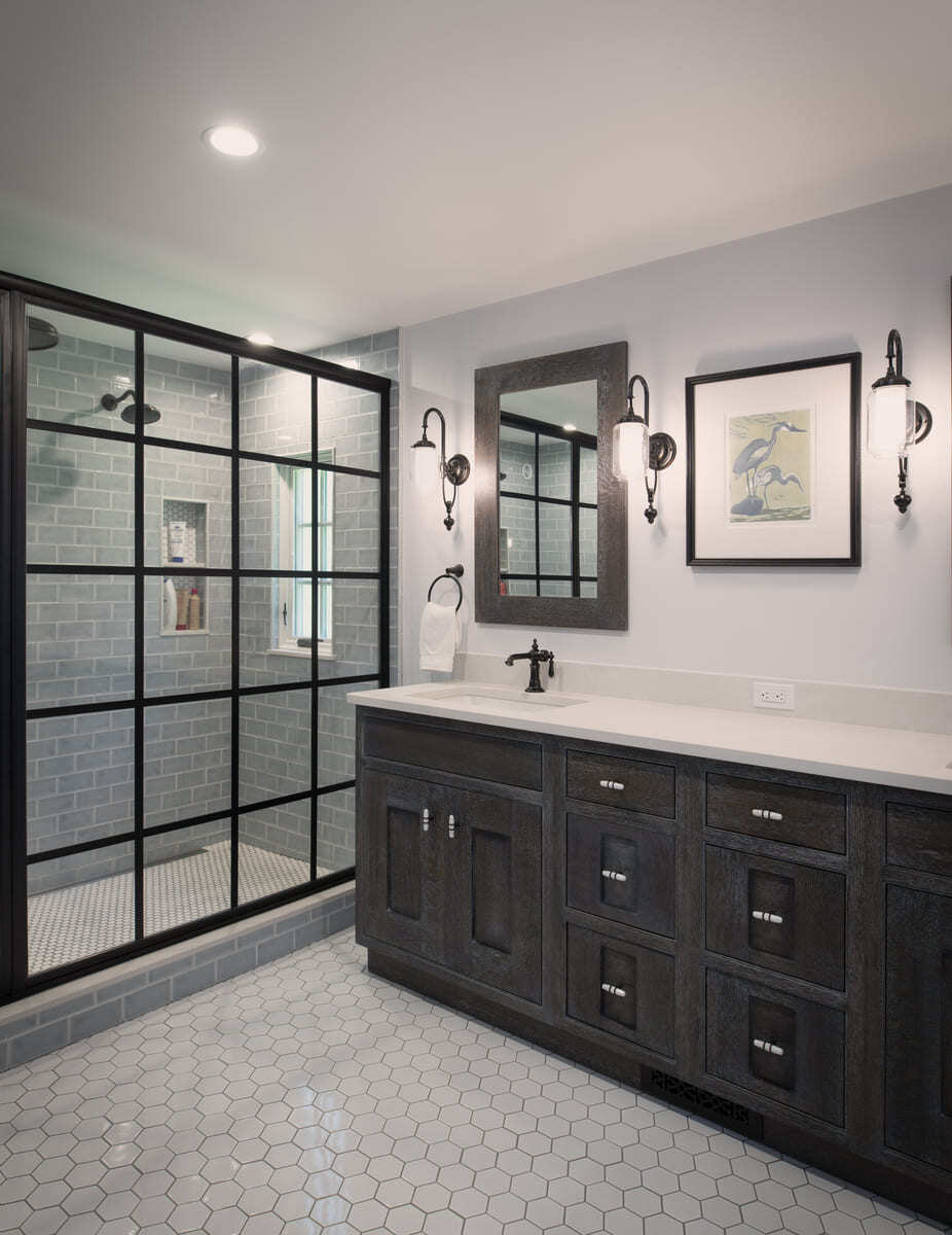 Sophisticated master bathroom with a spacious black-framed glass shower, soft gray subway tiles, and dark wood cabinetry in an Acton, MA renovation