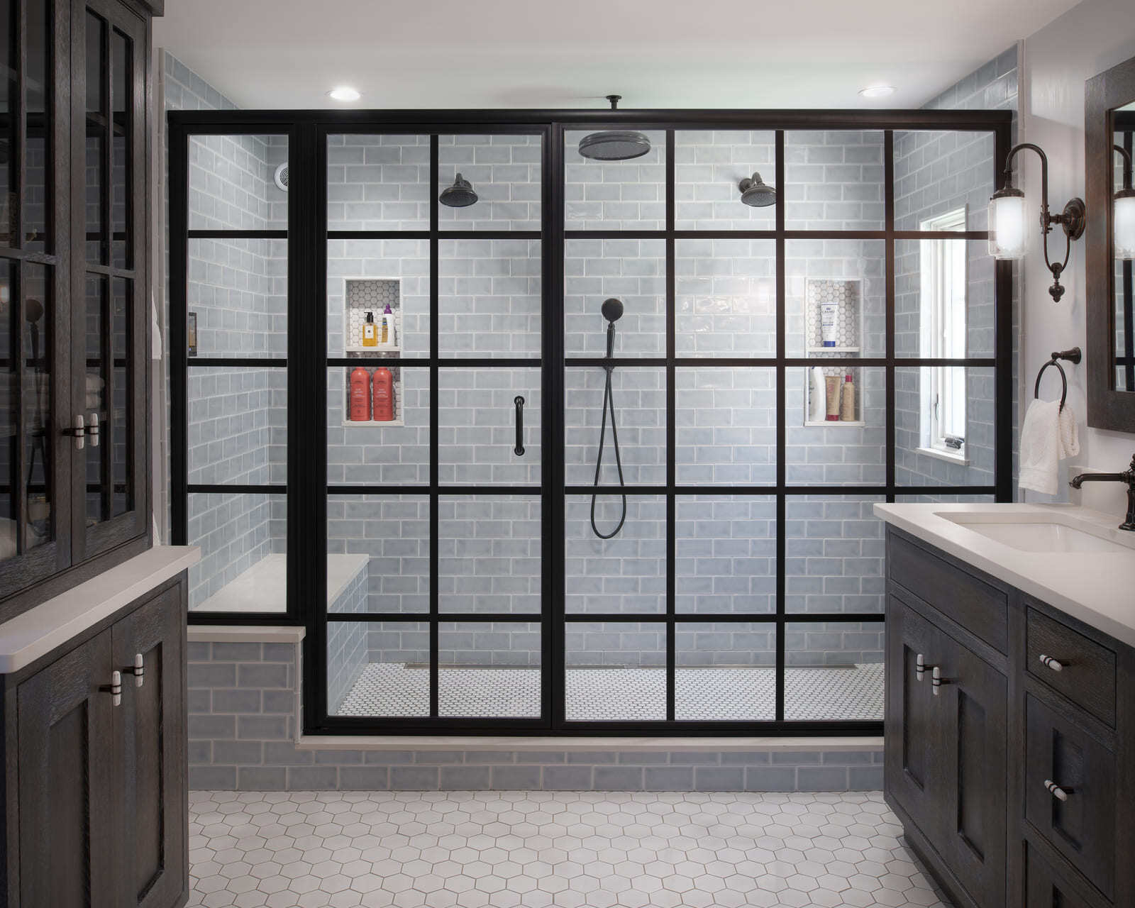 Stylish bathroom shower with large glass panels, gray subway tile, and a rain shower system in a Tucker Remodel by Thomas Buckborough & Associates